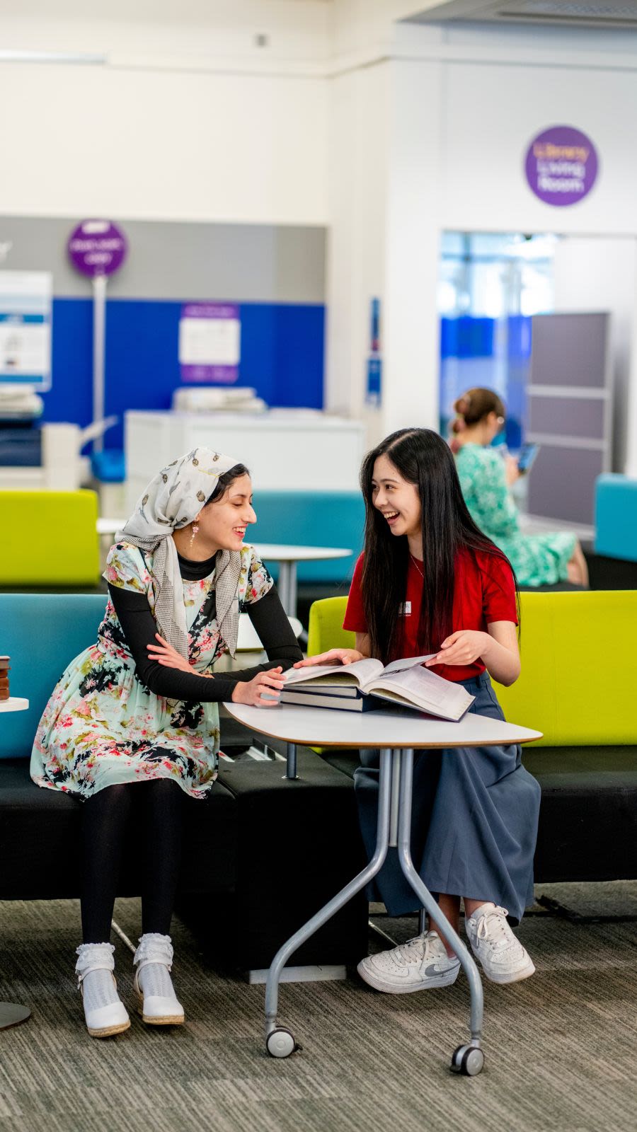 A student with a Student Team member sat laughing in Blue Ground, Main Library