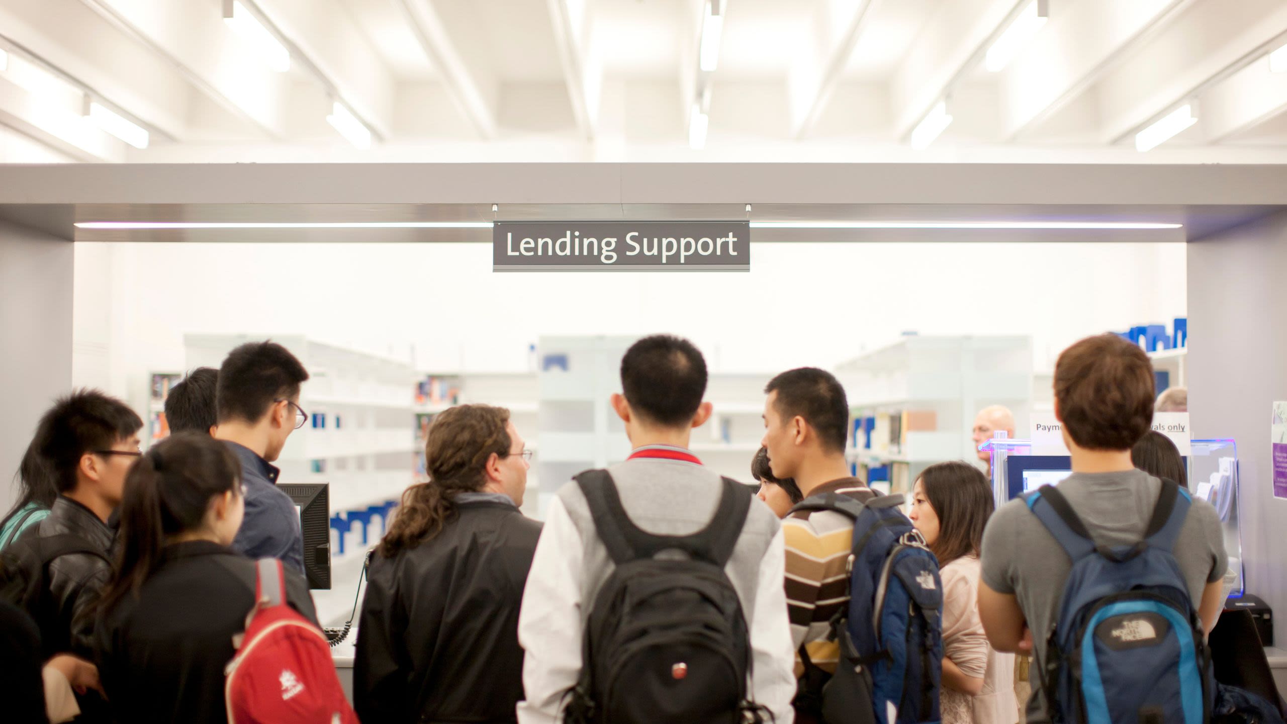 Students gather at a customer support desk in Main Libraryy