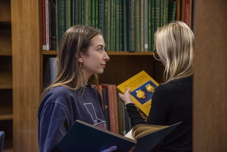 Students looking at books in Green 3 in Main Library