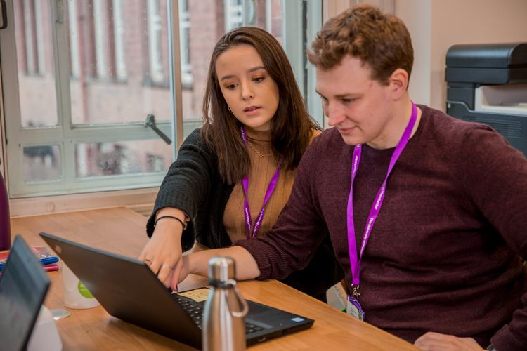 Staff working together in front of a laptop