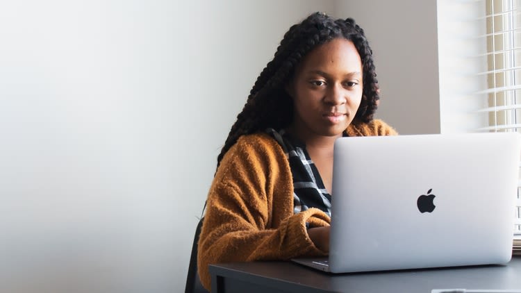 Woman working at a laptop by a window