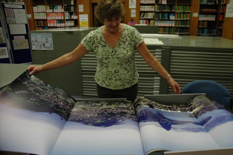 A member of staff unfurls an item from Special Collections