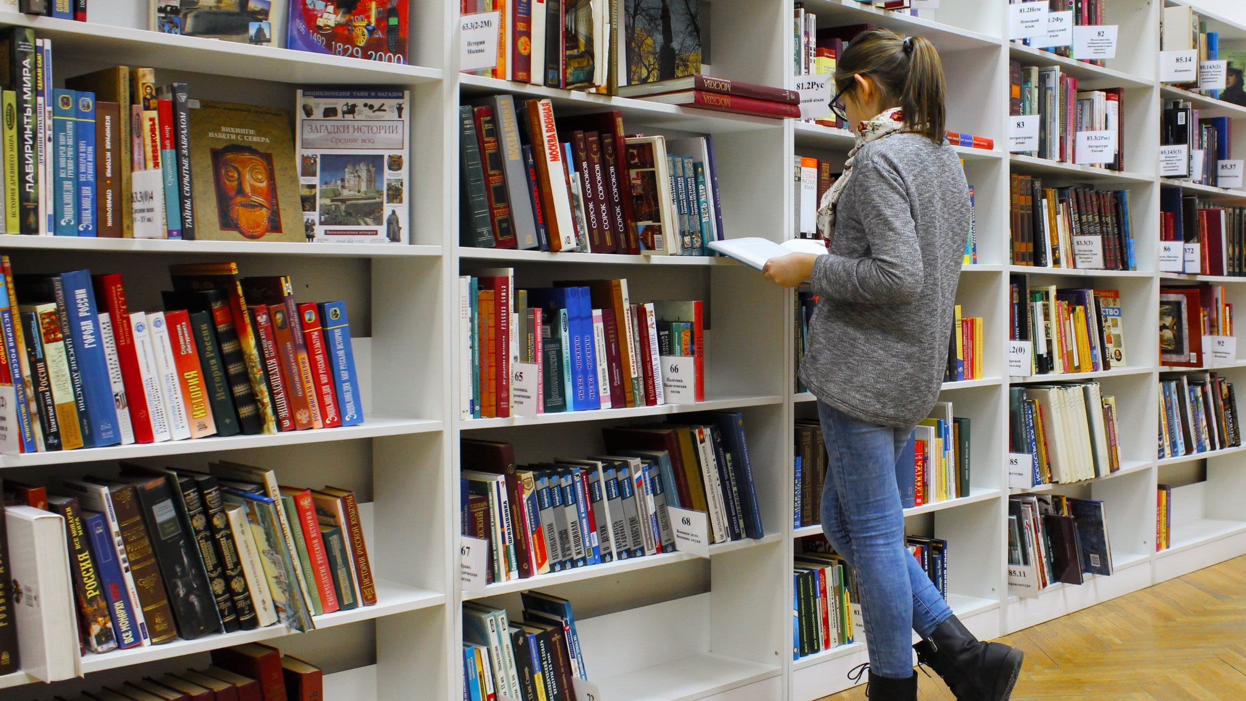 School pupil looking at books on shelves