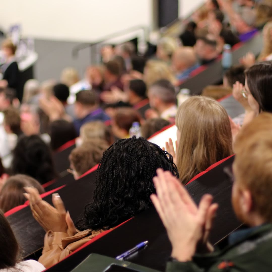 Audience in a lecture theatre watching a presentation