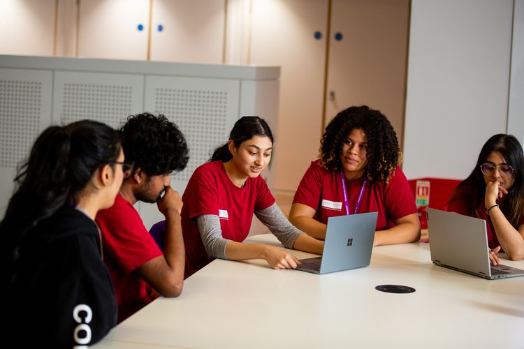 Members of the student team sat around laptops in AGLC