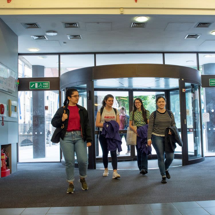 Group of students entering Main Library through revolving door