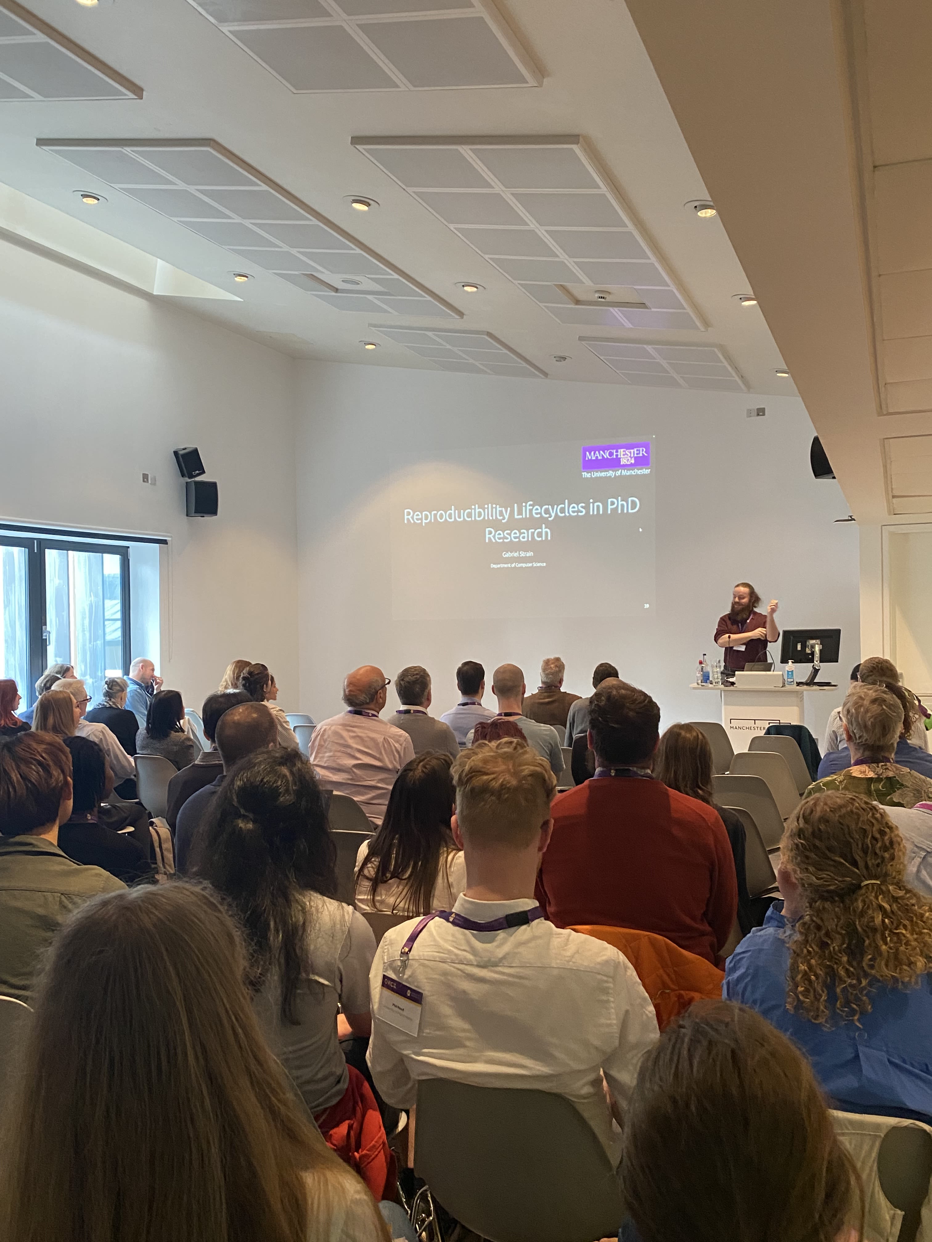 A presenter at the Open Research Conference 2024, watched by attendees