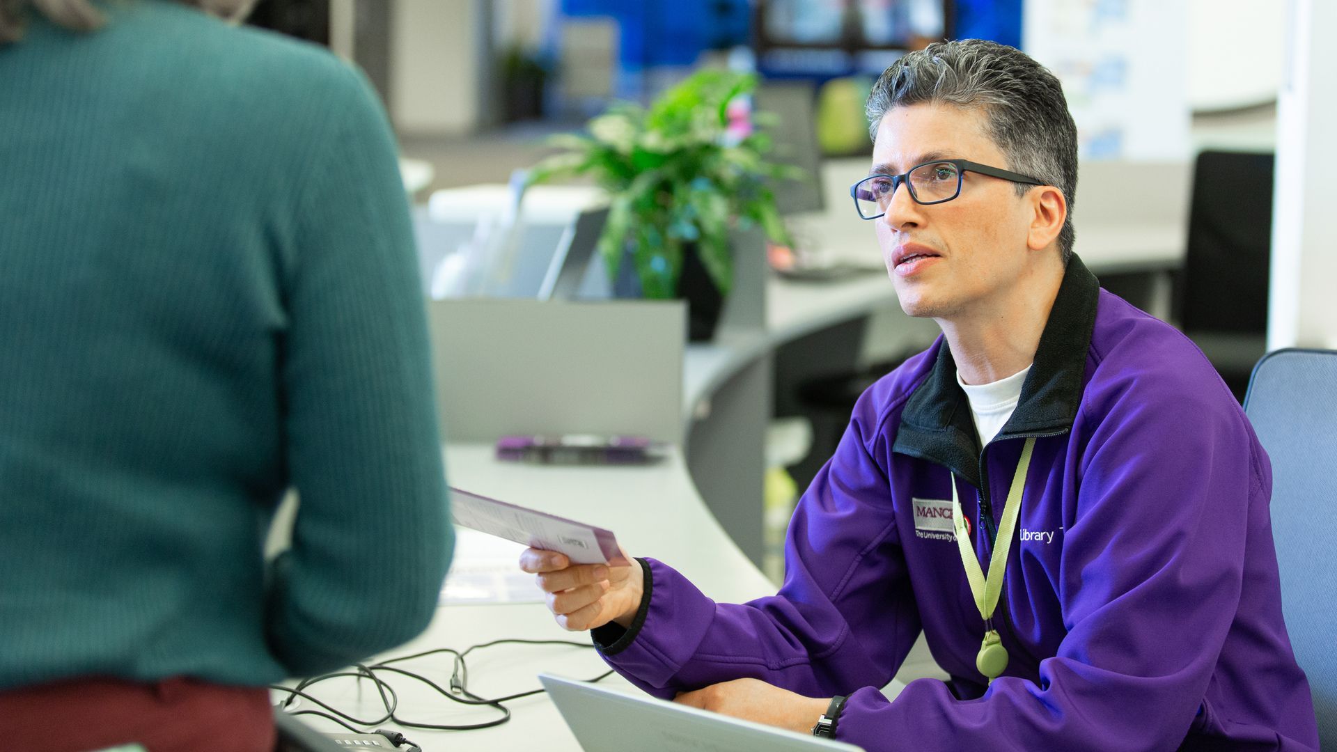 Member of Customer Services at reception in Main Library