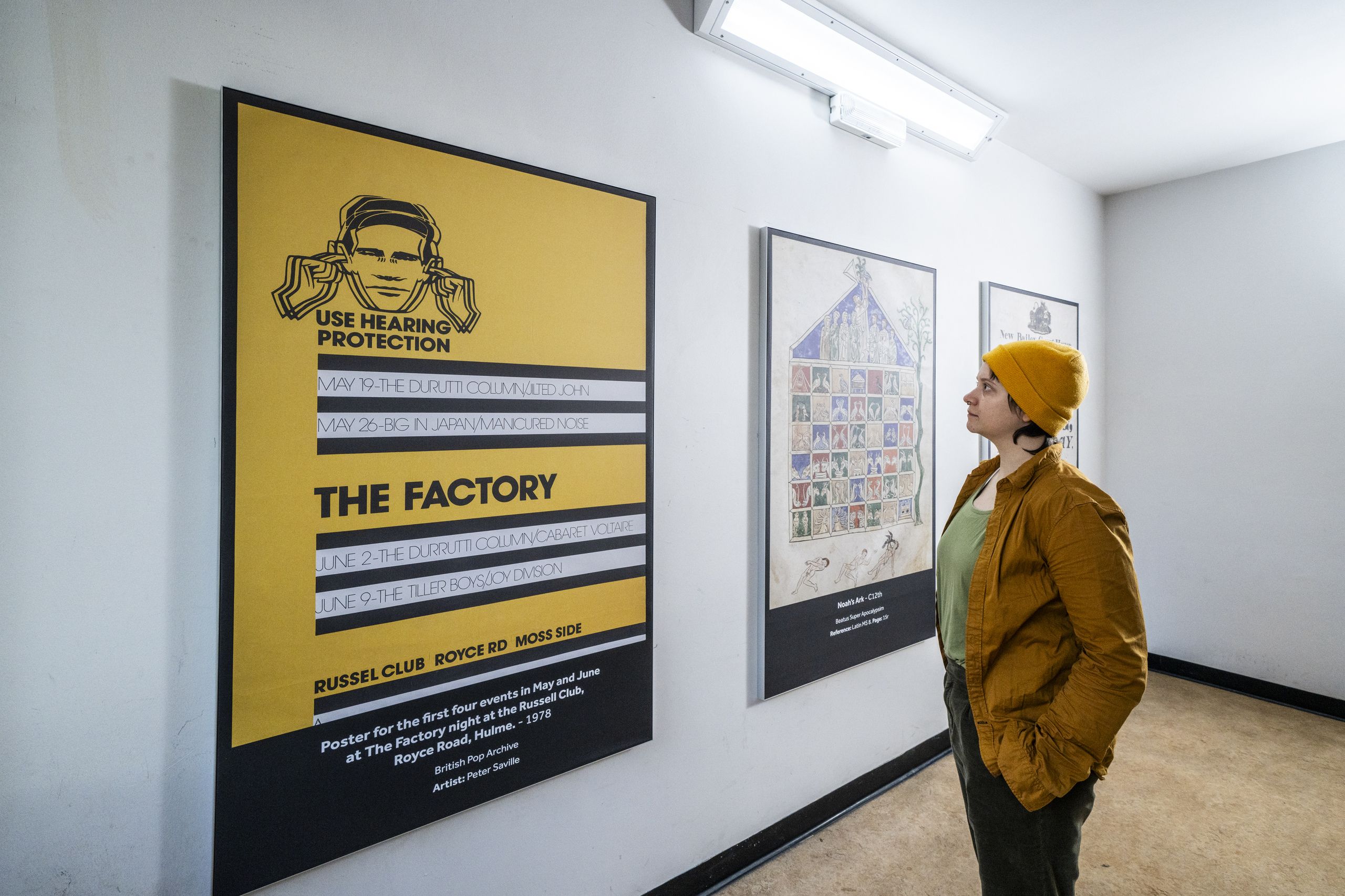 Student observing prints on the walls of the stairwells in Main Library