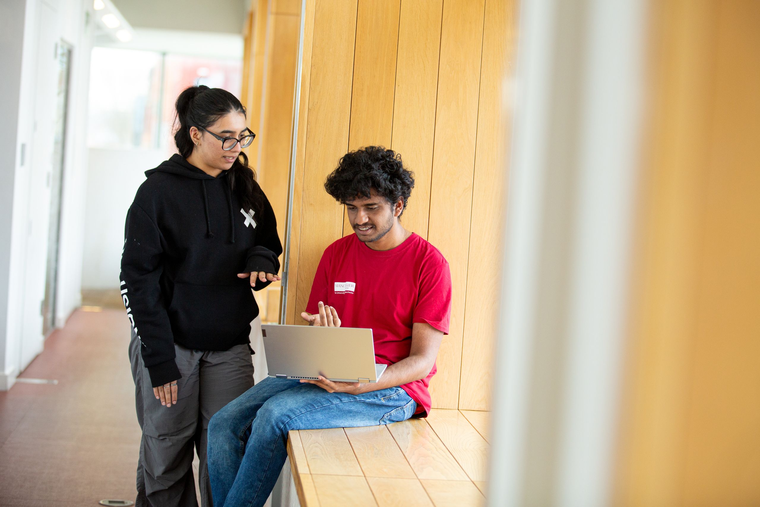 Two students in AGLC looking at a laptop