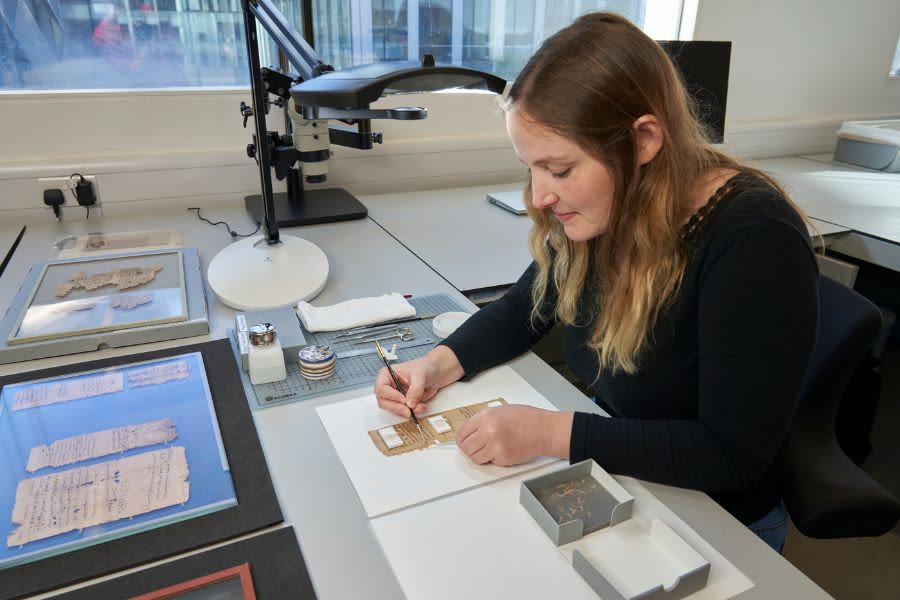 Member of collection care staff working on papyrus item