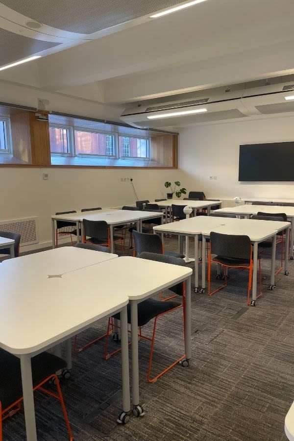 Tables set out in squares with chairs around them in the new AGLC training room