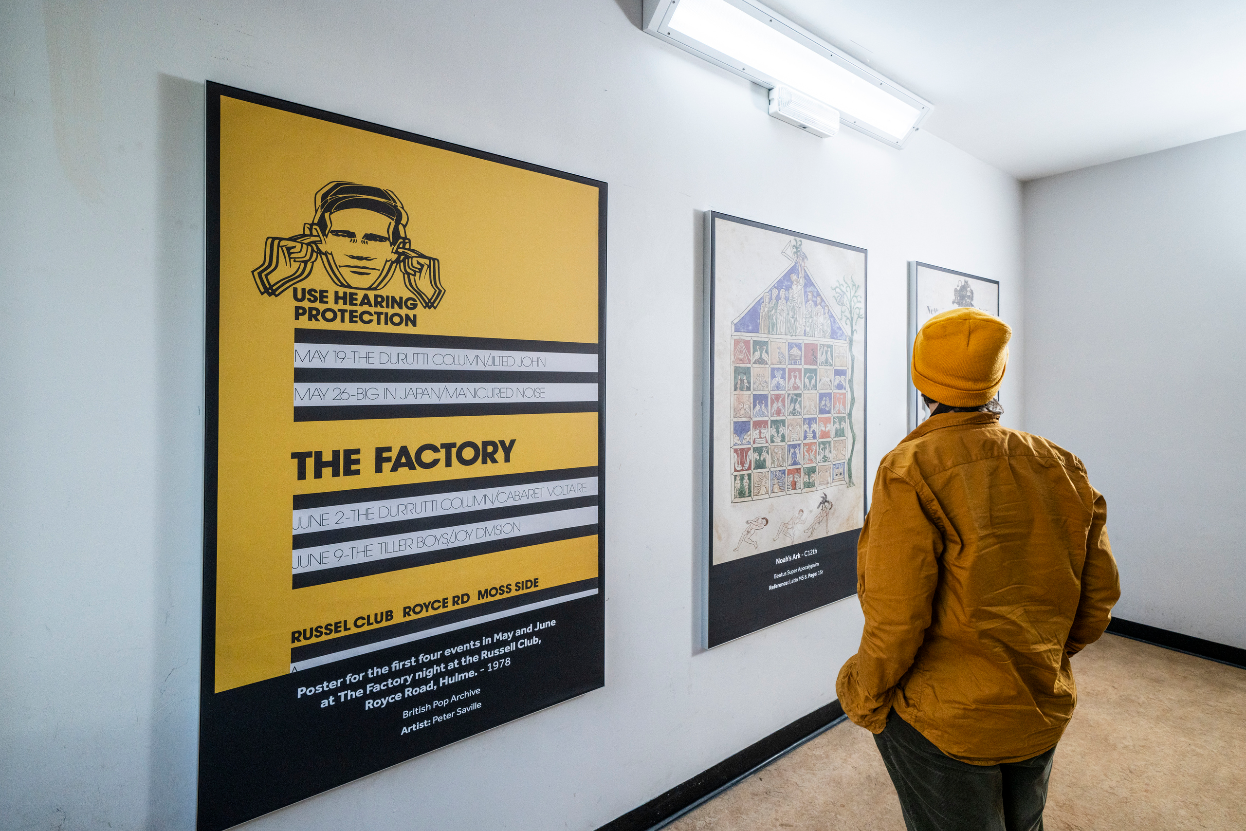 Student observing prints on the walls in the stairwells of Main Library