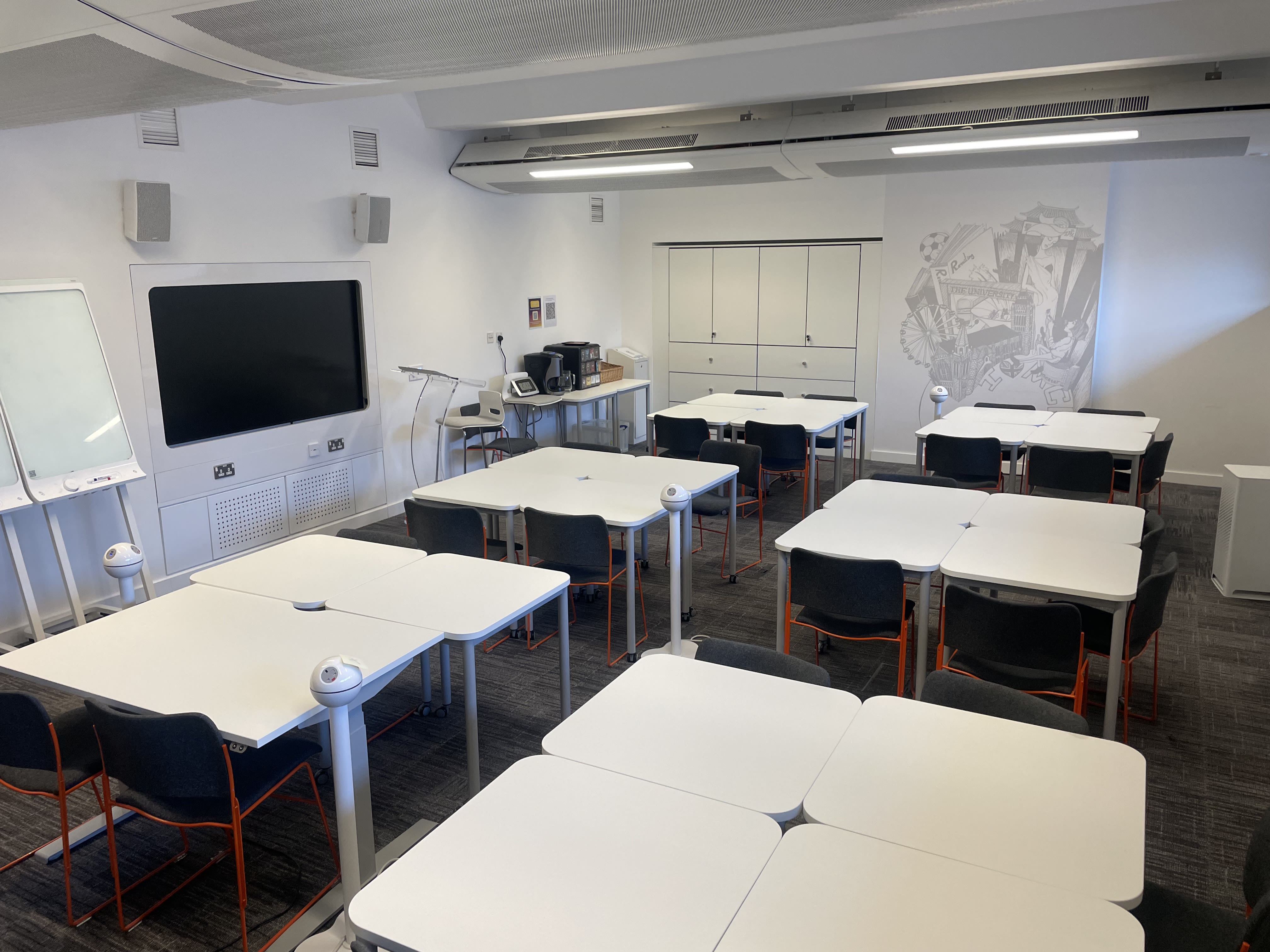 View of the training room in AGLC with tables set out in squares and screen at the front on the wall