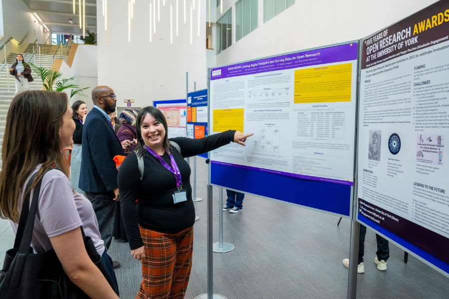 Two researchers looking excitedly at posters at the Open Research Conference 2025