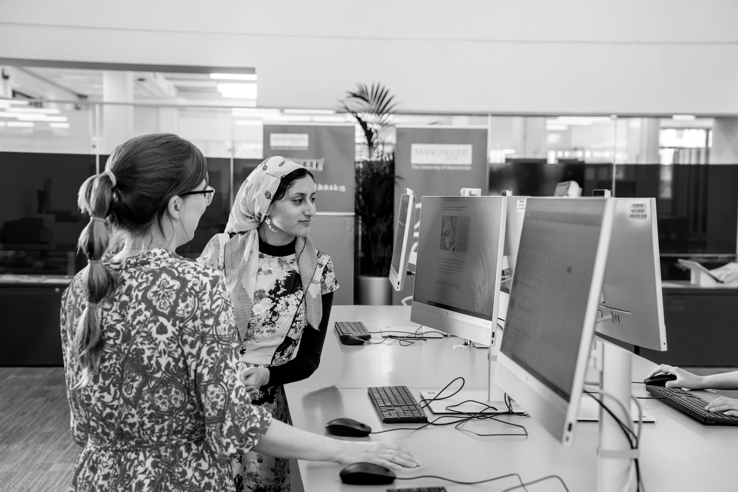 Two students standing at the quick use PCs in Blue Ground Main Library